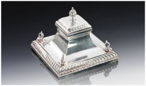 A Silver Desk Top Ink Stand with a square gadrooned base, surmounted with scroll motifs at each