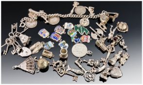 A Silver Charm Bracelet. Laded with silver charms and coins. 12 in total. 36 Loose silver charms.