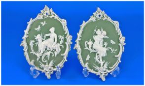 Pair of Green Bisque Wall Plaques, each with white Classical scenes of a cherub and a lady in