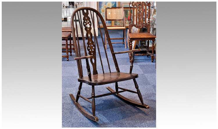 Windsor Style Rocking Chair, with ash seat, wheel pierced back splat, measuring 42 inches high.
