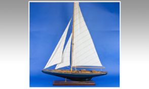 Large Wooden Model of a 20th Century Yacht, fitted with huge sails, propeller to stern, raised on