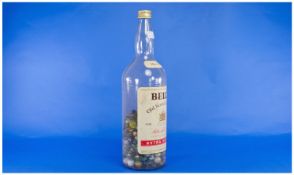 Large Glass Bottle of Bell`s Scotch Whisky, half filled with a various collection of marbles.