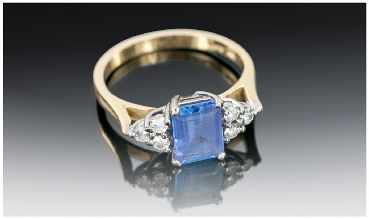 Ladies 18ct Gold Tanzanite Emerald Cut Ring, the centre Tanzanite flanked by six small diamonds. The