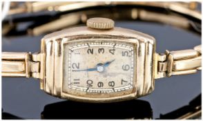 Ladies Art Deco 9 Carat Gold Wristwatch supported on 9 carat gold bracelet with metal core.