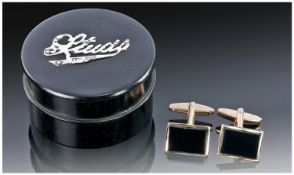 An Ebony and Silver Box containing a pair of silver gilt cufflinks. The round ebony box with screw