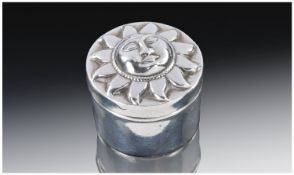 A Round Sterling Silver Pill Box. The pull off lid decorated in relief with the face of the sun god.