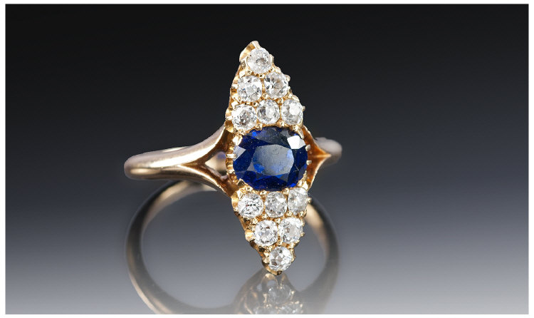 Victorian Ladies 15 Carat Gold Sapphire and Diamond Ring. The central sapphire flanked by 12 cushion