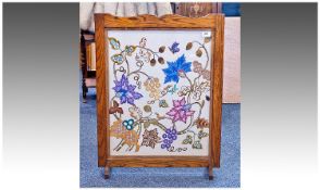 Large Oak Framed Fire Screen, circa 1900, the panel embroided with woodland foliage scenes, with