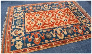 Medium Sized Hand Made Woolen Turkish Rug with geometrical pattern to centre, on a red ground,