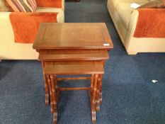 Nest of Three Yew Veneered Tables, modern, raised on turned supports.