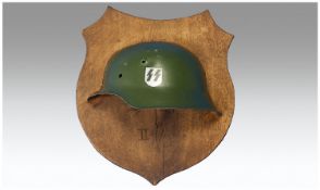 Half WW2 German SS Helmet on wooden plaque.