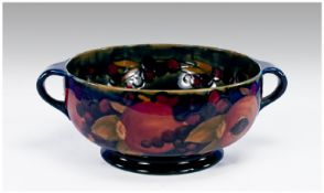 William Moorcroft Signed Two Handled Footed Bowl. Pomegranate and berries design on blue ground,