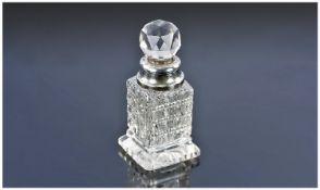 A Silver Collared Diaper Cut Glass Scent Bottle with Faceted Stopper and square spreading foot.