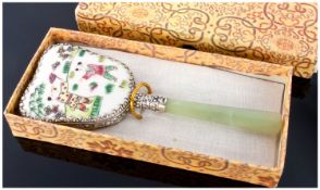 A Chinese Handmirror. Green jade handle and white metal surround. The reverse hand enamelled in pink