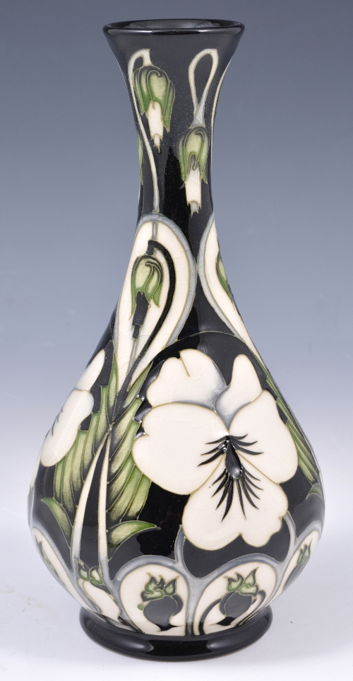 A Moorcroft pottery bottle vase, stylised floral decoration on a black ground, impressed marks and