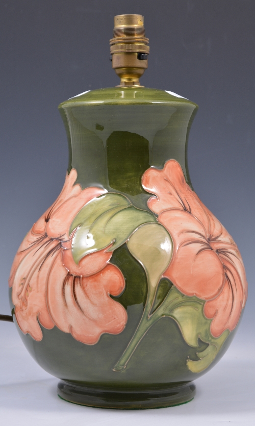 A Moorcroft pottery pear shaped lamp base, Hibiscus design on a green ground, 33cm overall.