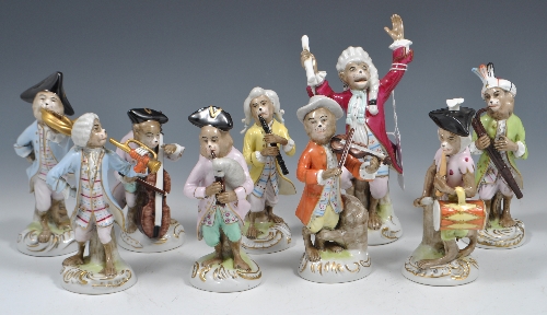 Set of nine Continental porcelain monkey band figures, probably Sitzendorf, each on a scrolled