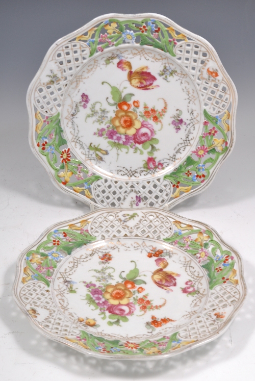 Pair of Continental ribbon plates, pierced flanges, floral decoration, diameter 21cms.