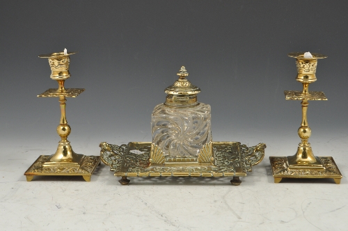 Edwardian cast brass desk stand, with a glass inkwell, width 22cms and a pair of brass candlesticks,