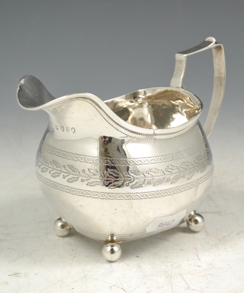 George III silver cream jug, London 1811, engraved laurel and guilloche bands, 10cms.