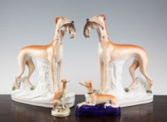 A pair of Staffordshire pottery models of greyhounds and two other similar, late 19th century, the