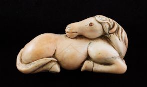 A rare Chinese carved coral figure of a recumbent horse, Qing dynasty, its head turned backward with