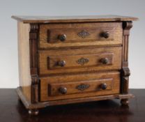 A 19th century North European miniature oak chest, fitted three long drawers, on bun feet, 1ft H.