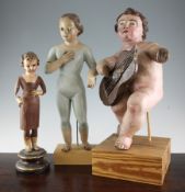 A 19th / 20th century Spanish painted pine figure of a musical putto, damaged, together with two