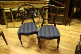 A set of four Victorian walnut dining chairs, with buckle backs and padded seats, and a pair of