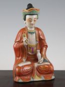 A Chinese enamelled porcelain seated figure of Guanyin, holding a vase in her left hand, 8.6in. (