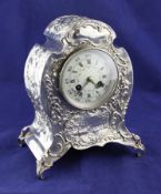 A late Victorian rococco style repousse silver cased mantel clock, by William Comyns, of shaped