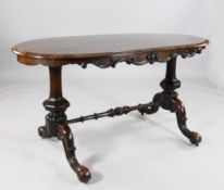 A Victorian rosewood centre table, with oval top on hexagonal baluster end standards and scroll