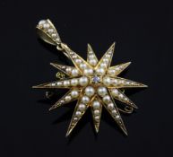 An Edwardian 18ct gold, split pearl and diamond set starburst pendant brooch, 2in inc. bale.