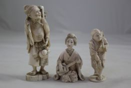 Three Japanese ivory figures, Meiji period, the first an old man holding a lantern, the second a