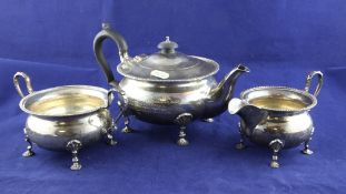 A George VI silver three piece tea set, of squat circular form, with gadrooned borders and