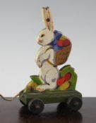 An unusual Steiff painted wood pull-a-long rabbit, on four wheels with Steiff button to the ear on