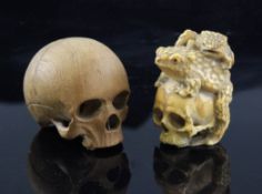 A Japanese walrus ivory okimono of two toads clambering over a human skull, Meiji period unsigned,