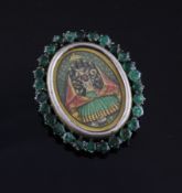 An Indian gilt metal mounted oval miniature with emerald set border, 1.5in.