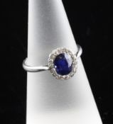 A 1920`s platinum, sapphire and diamond cluster ring, with oval cut sapphire and diamond set border,