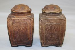 A pair of Yixing pottery square tea caddies and covers, each moulded with twin fish and trees,