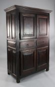 An 18th century provincial French cupboard, fitted four panelled doors and two drawers, 4ft 1in.