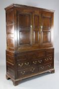 An 18th century oak press cupboard, with two panelled doors over five long drawers, 4ft 6in. H.6ft