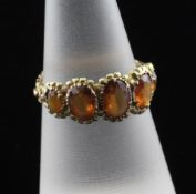 A Victorian gold and graduated five stone hessonite garnet half hoop ring, with carved shank and