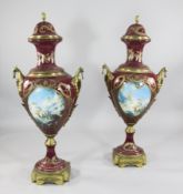 A pair of tall Sevres style magenta ground vases and covers, with gilt metal mounts, decorated