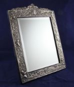 A 1990`s Britannia standard repousse silver mounted rectangular easel mirror, with domed top and