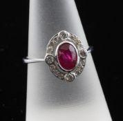 A white gold, ruby and diamond cluster ring, of oval form, size O.