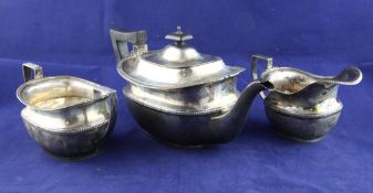 A George V silver three piece tea set, of rounded rectangular form, with banded girdle and reeded