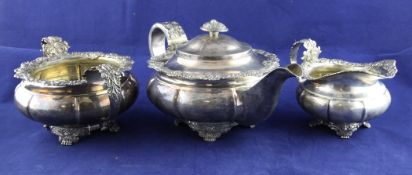 A matched George IV silver three piece tea set, of squat melon form, with cast foliate borders, on