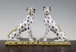 A pair of Continental faience seated hounds, with black spotted coats, 8.5in.