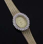 A lady`s Swiss 14ct gold and diamond set quartz wrist watch, the oval dial with baton numerals and